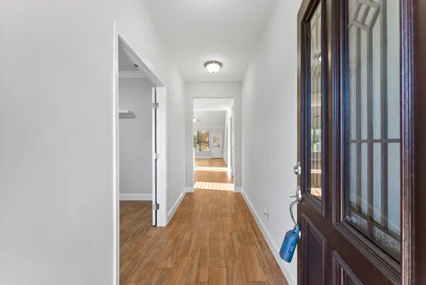a view of a hallway with wooden floor and staircase