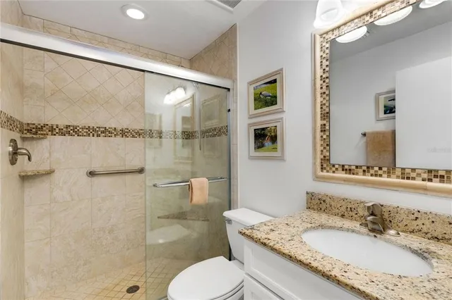 a bathroom with a granite countertop sink toilet and shower