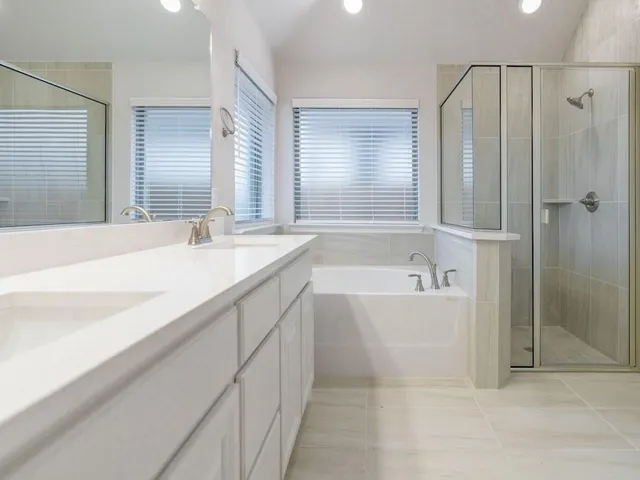 a spacious bathroom with sink shower and bathtub