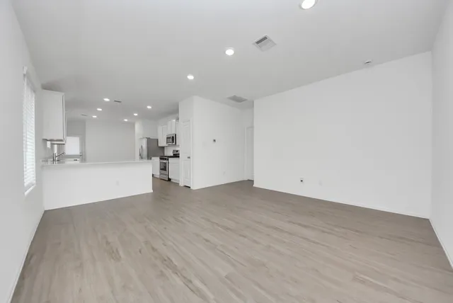 a view of an empty room with a kitchen