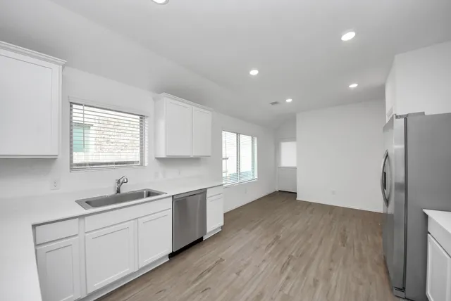 a kitchen with a sink a refrigerator and window
