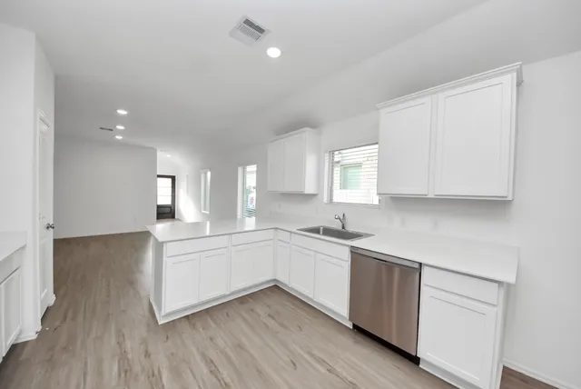 a kitchen with a sink cabinets and wooden floor
