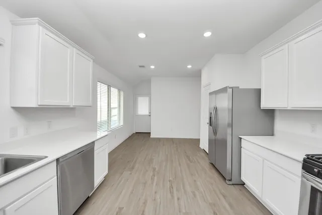 a kitchen with stainless steel appliances a refrigerator and a sink