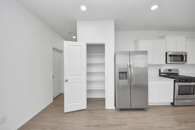 a kitchen with stainless steel appliances a refrigerator and a stove top oven