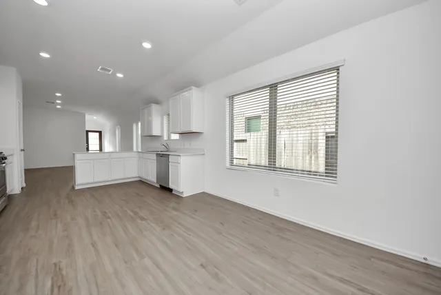 a view of a kitchen with wooden floor and windows
