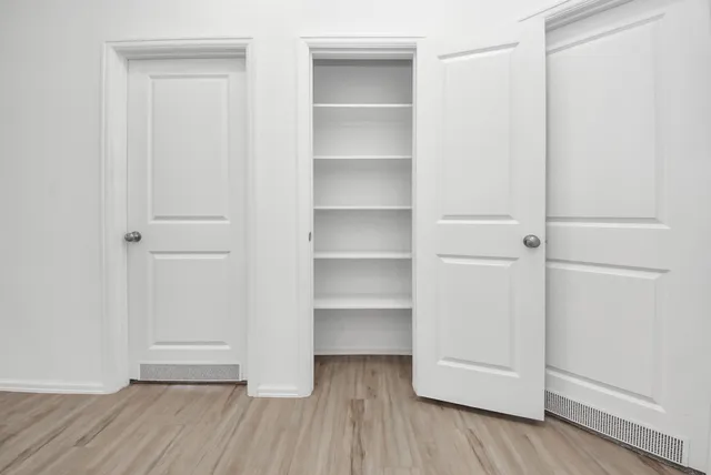 a view of walk in closet with empty racks