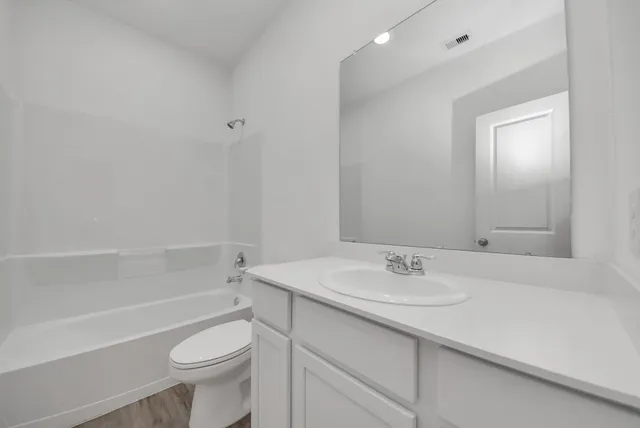 a bathroom with a sink toilet vanity and tub