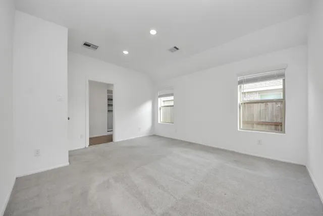 an empty room with windows and closet