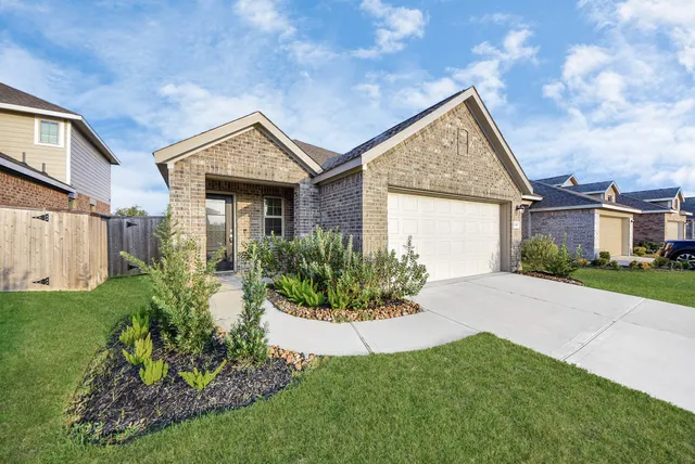 a view of a house with a small yard and flower plants