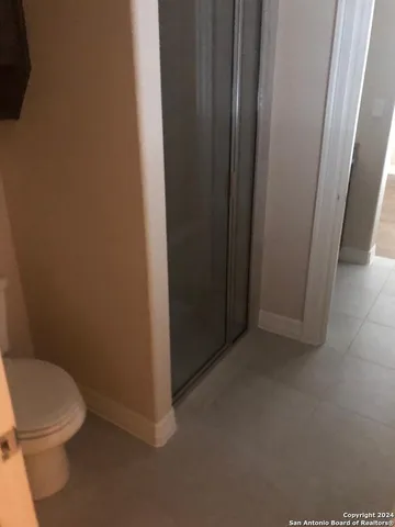 a white toilet sitting next to a shower