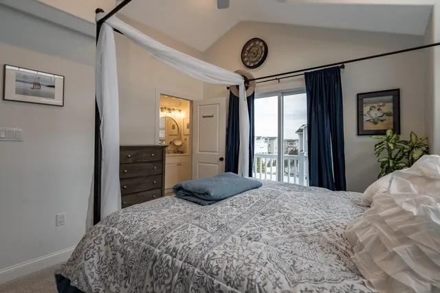 a bedroom with a bed and a large mirror on the dresser