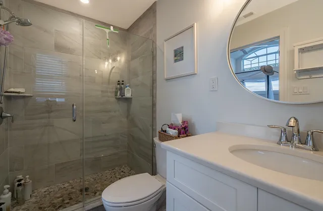 a bathroom with a sink a toilet and shower