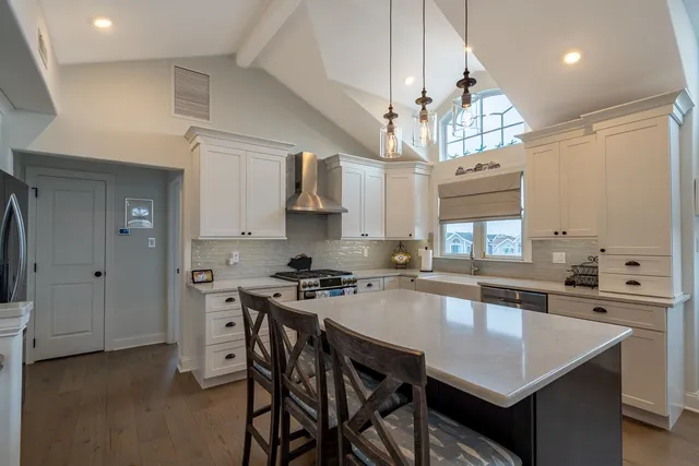 a kitchen with stainless steel appliances a kitchen island a stove a table and chairs in it