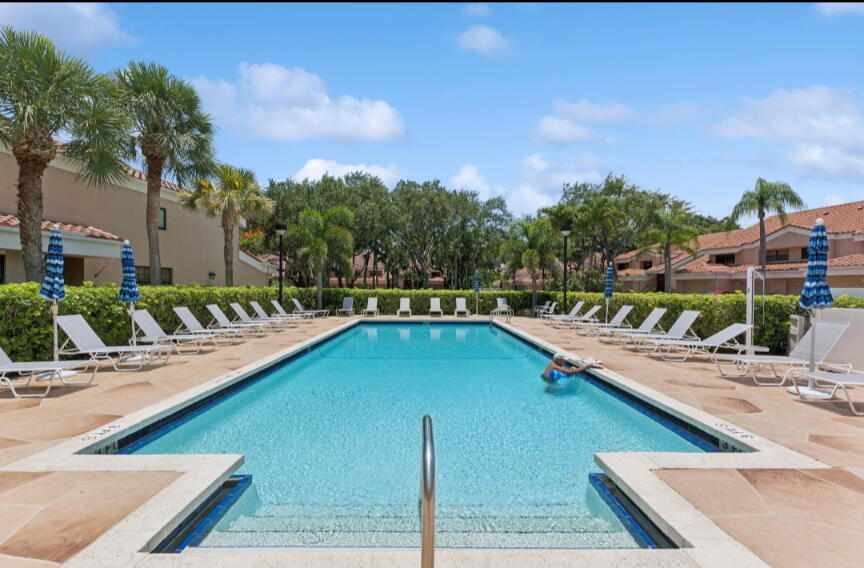 17372 Boca Club Boulevard, Unit 405 Boca Raton, FL 33487 - Photo 63 of 74 a view of a swimming pool with a lounge chair