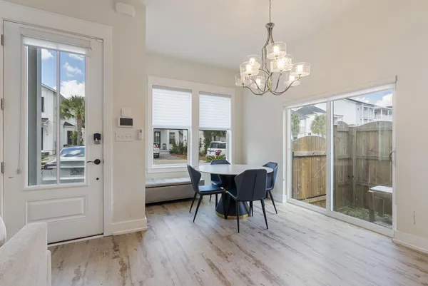 a view of a dining room with furniture a chandelier and wooden floor