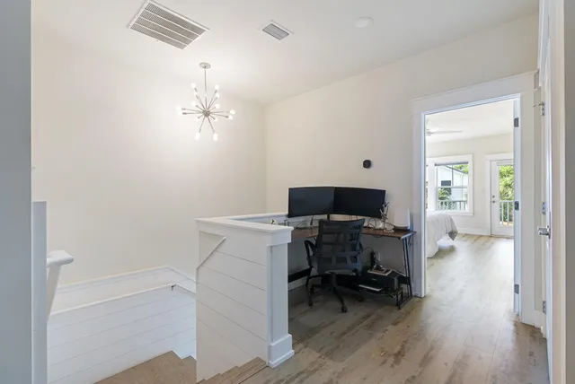 a view of a workspace with furniture and wooden floor
