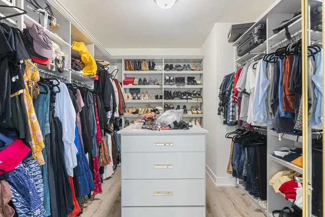 a view of walk in closet with clothes and shoes