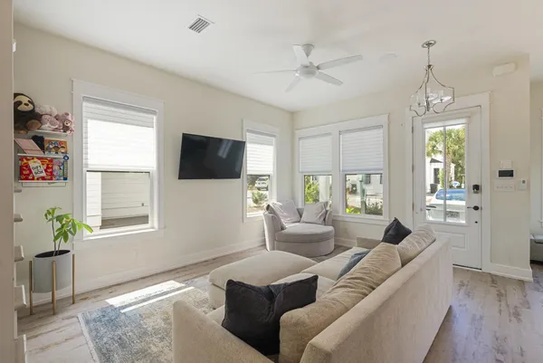 a living room with furniture a ceiling fan and a window