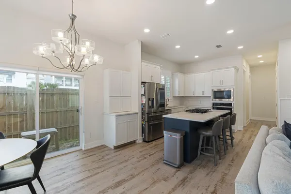 a kitchen with kitchen island a wooden floor and white appliances