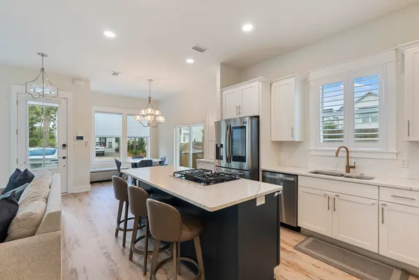a kitchen that has a table chairs in it and wooden floors