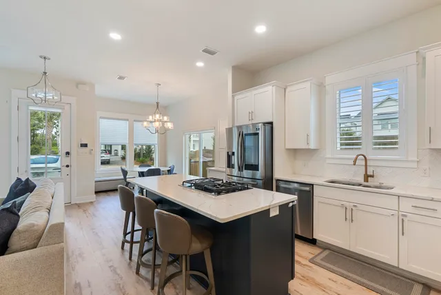 a kitchen that has a table chairs in it and wooden floors