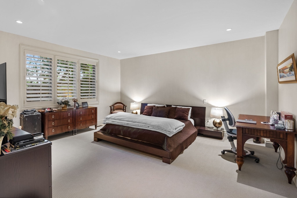 99 Baldpate Hill Road Newton, MA 02459 - Photo 14 of 28 a spacious bedroom with a bed a couch and a window