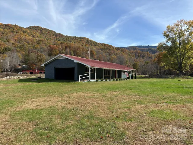 a front view of house with yard and mountain in the background