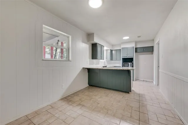 a kitchen with stainless steel appliances kitchen island granite countertop a refrigerator and a stove top oven