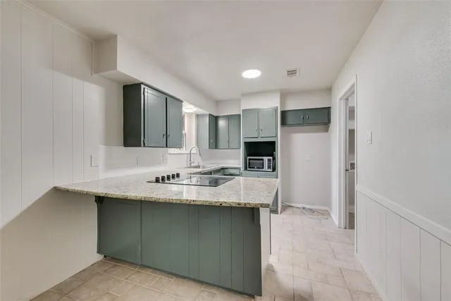 a kitchen with kitchen island a sink stainless steel appliances and cabinets