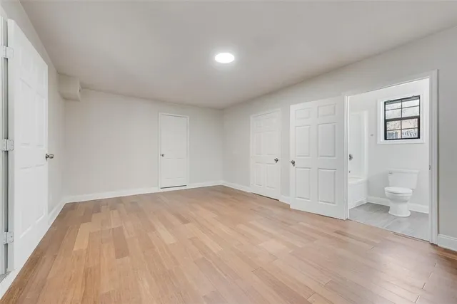 a view of empty room with wooden floor and window