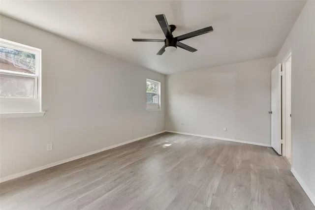 a view of a big room with wooden floor and windows