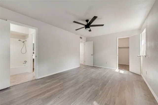 a view of empty room with wooden floor and window