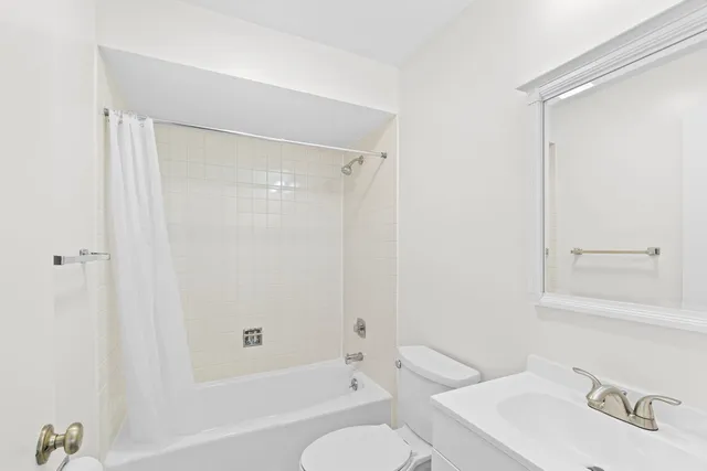 a bathroom with a bathtub shower sink vanity and toilet