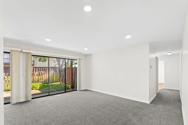 an empty room with floor to ceiling windows and yard