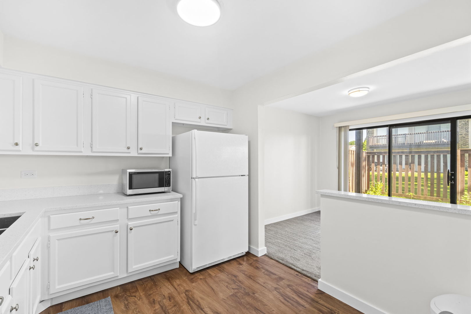 5880 Rembrandt Court, Unit C Hanover Park, IL 60133 - Photo 16 of 22 a kitchen with white cabinets and wooden floor