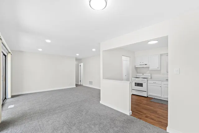 a view of a kitchen with white cabinets and stainless steel appliances
