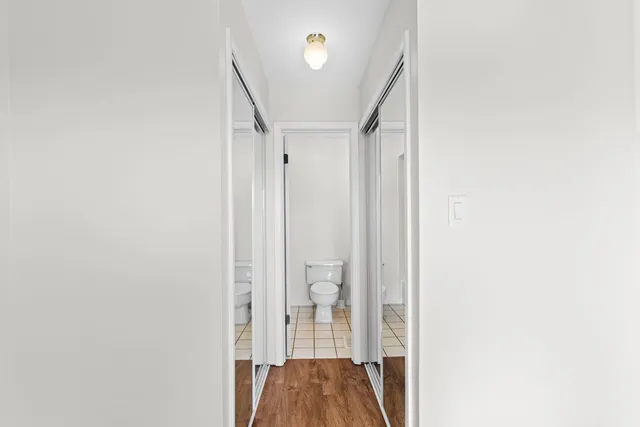 a view of a hallway with wooden floor and staircase