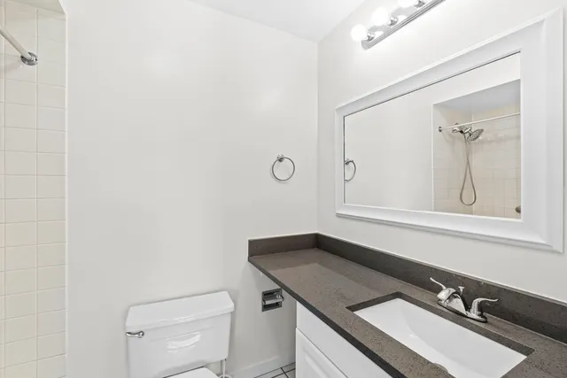 a bathroom with a granite countertop sink and a mirror