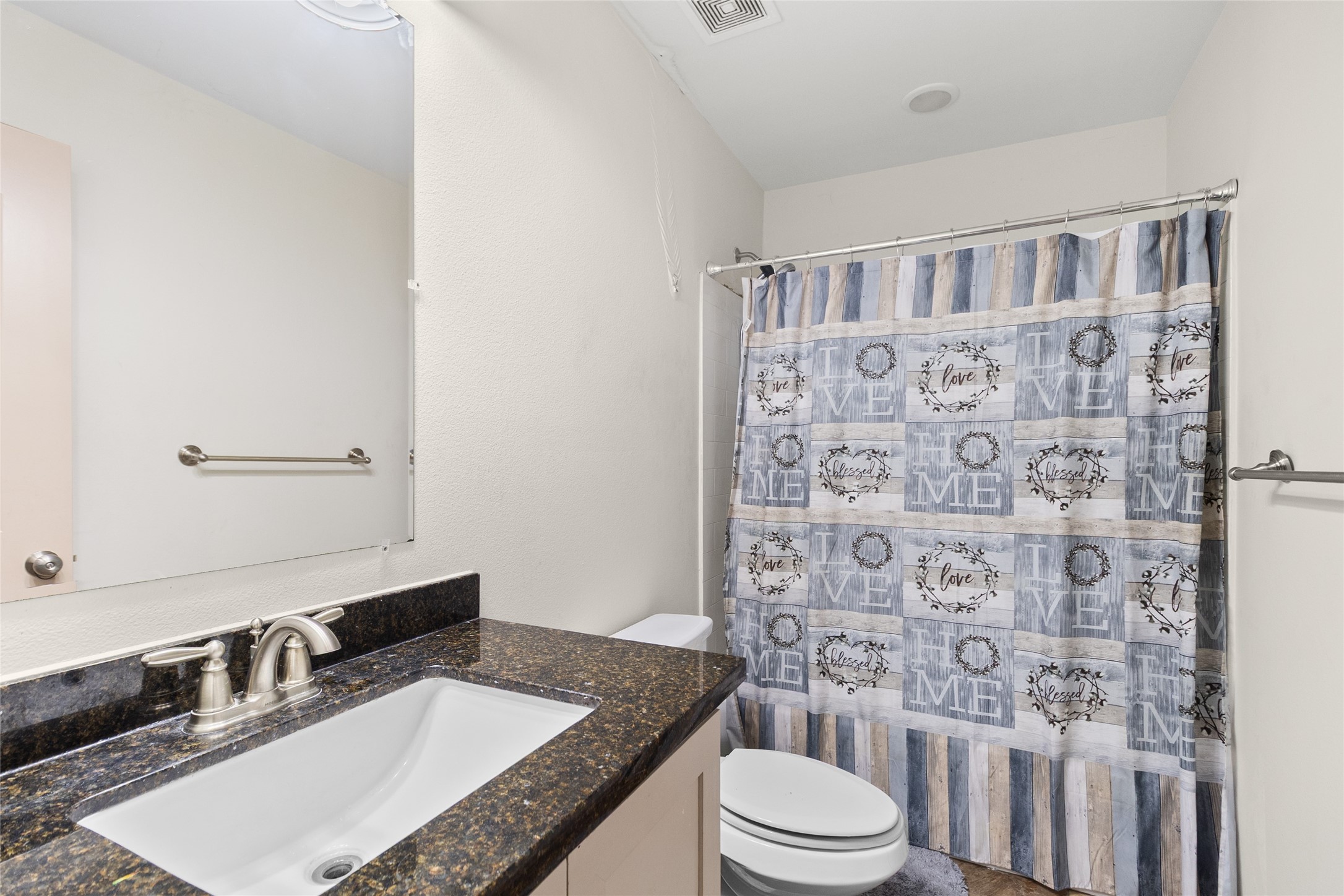 1545 County Road 2145 Cleveland, TX 77327 - Photo 7 of 22 a bathroom with a granite countertop toilet sink and mirror