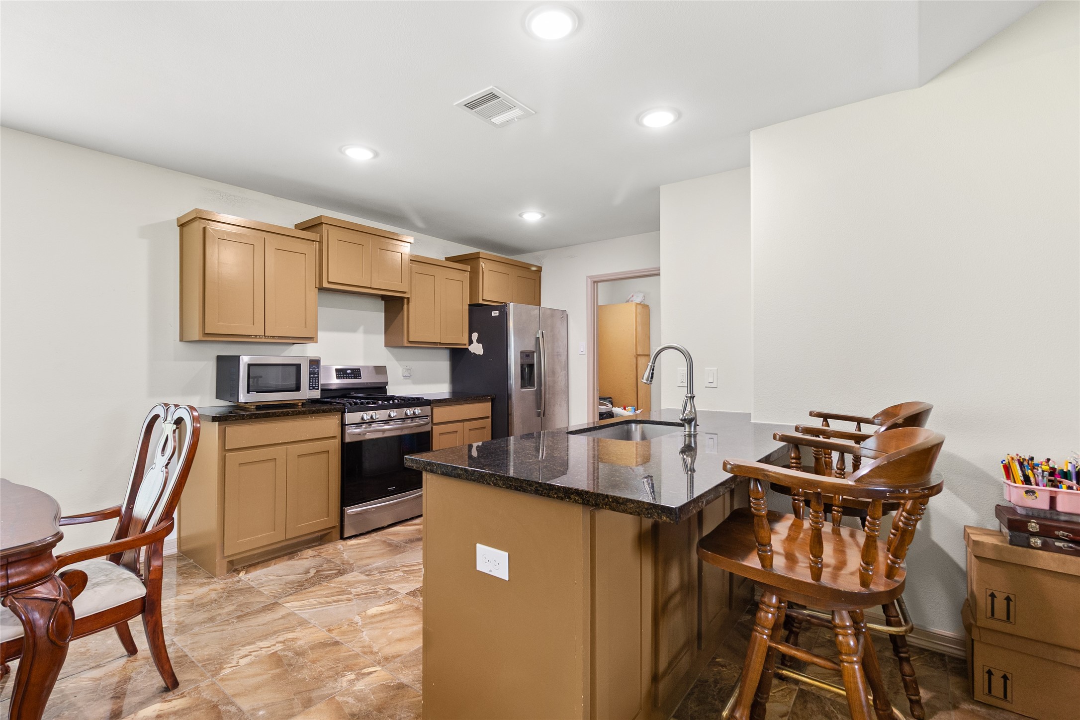 1545 County Road 2145 Cleveland, TX 77327 - Photo 9 of 22 a kitchen with stainless steel appliances granite countertop a stove and a refrigerator