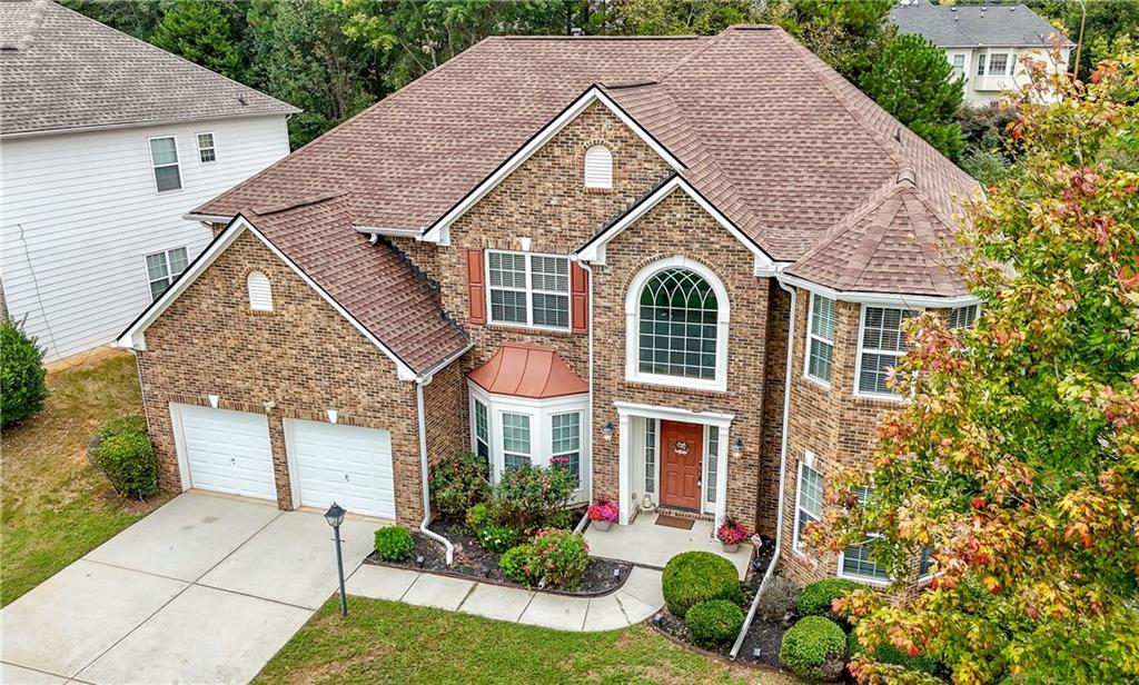 a front view of a house with a yard and potted plants