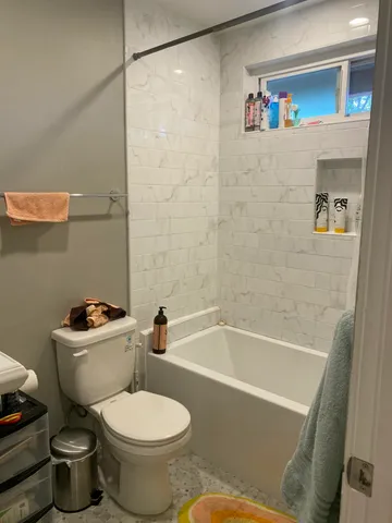 a white toilet sitting next to a bath tub