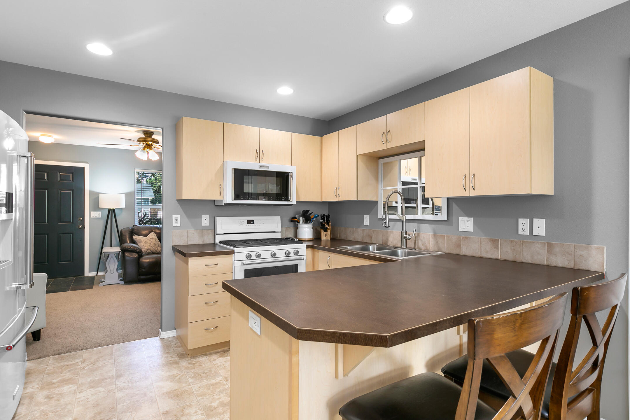 21363 Pecoraro Loop Bend, OR 97701 - Photo 7 of 15 a kitchen with a stove a sink a microwave a dining table and chairs