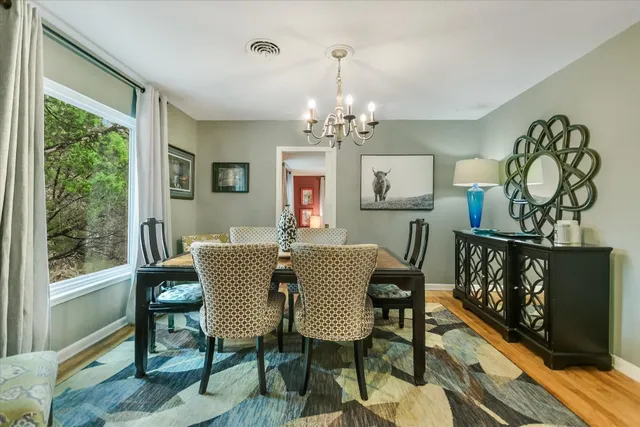 a kitchen with a stove a refrigerator and chairs