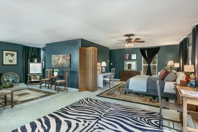 a living room with furniture a flat screen tv and a refrigerator