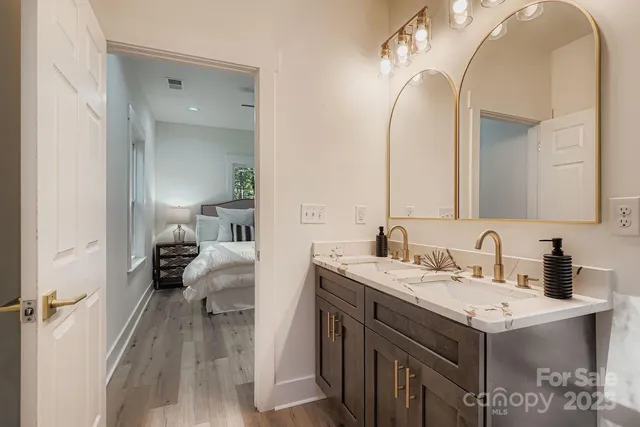 a en suite bathroom with a granite countertop sink and a mirror