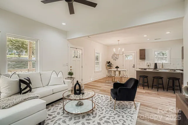 a living room with furniture kitchen view and a window
