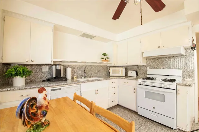 a kitchen with white cabinets and white appliances