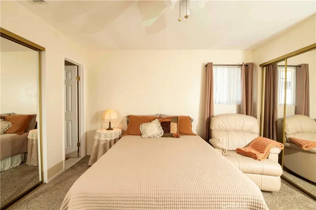 a bedroom with a bed large window and a chandelier