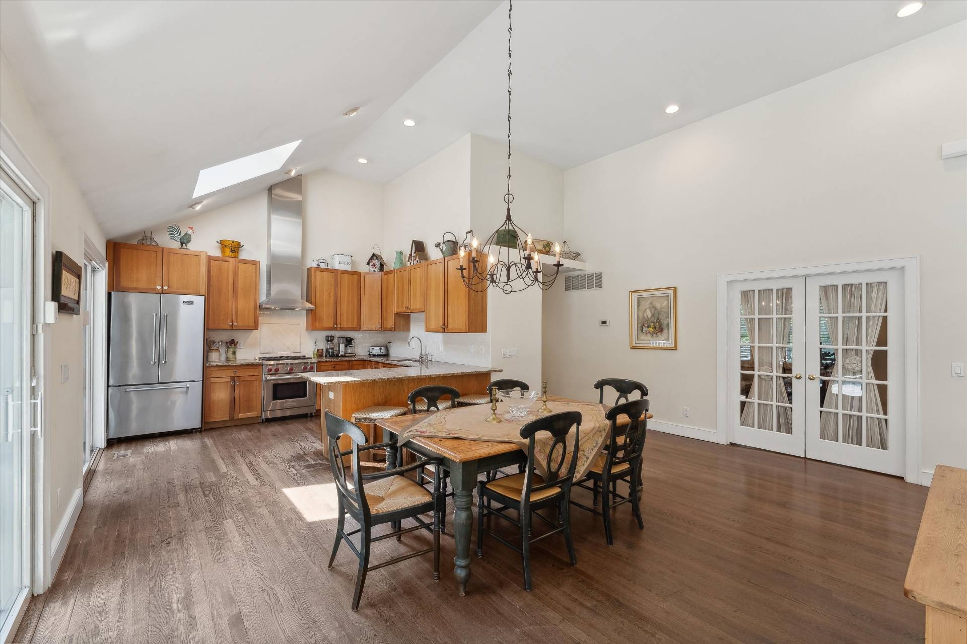 18 Old Fields Lane Quogue, NY 11959 - Photo 14 of 34 a dining room with stainless steel appliances kitchen island granite countertop a table chairs and a refrigerator